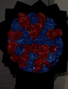 a bouquet of red, white and blue hearts on a black paper bag in front of a door