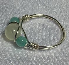 a pair of green and white glass beads on a silver wire hook - through ring