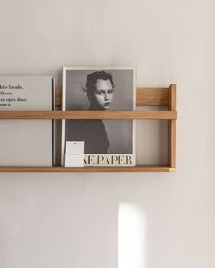 a shelf with some books on top of it and a photo hanging from the wall