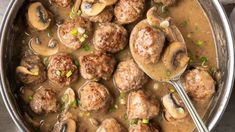 a pan filled with meatballs and mushrooms covered in gravy on top of a table