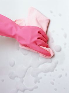 a pair of pink gloves on top of a white surface with water drops around it