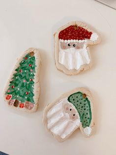 three decorated cookies sitting on top of a table