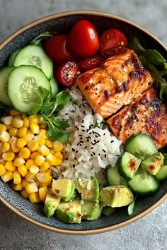 a bowl filled with rice, cucumber, tomatoes, corn and other vegetables