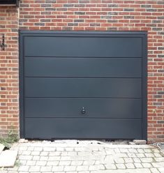 a black garage door on a brick building