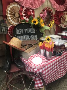 a red and white checkered table cloth with sunflowers on it next to a sign that says get your grill on