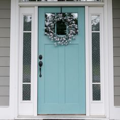 a blue front door with a wreath on it