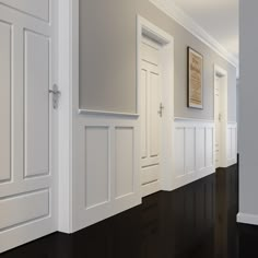 an empty hallway with white doors and black floors