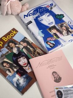 three books and a stuffed animal are on the table next to each other, including one book