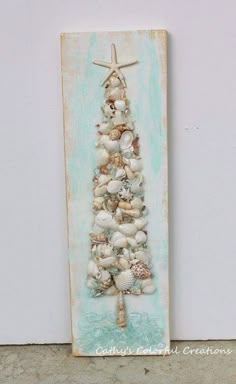 a metal christmas tree made out of seashells