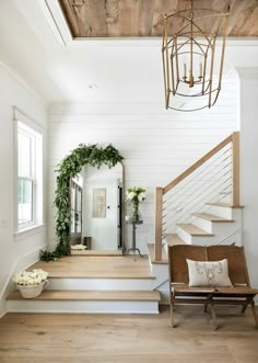 a staircase with white walls and wooden steps leading up to the second floor, along with a mirror on the wall