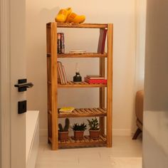 a wooden shelf with books and plants on it