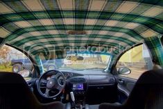 the interior of a car with plaid cloth covering it's roof and dash board