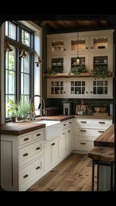 a kitchen filled with lots of white cabinets and wooden counter tops next to a window