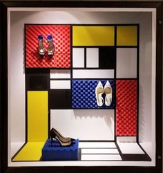 a display case with shoes and footwear on the shelf in front of it is a multi - colored background