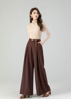 "Carefully crafted from luxurious wool, these full-length trousers provide the ultimate blend of fashion and warmth. Their flattering wide-leg design adapts to various occasions, and the deep chestnut brown shade exudes timeless sophistication. Whether you're heading to the office or a festive gathering, these wool pants ensure you stay stylish and snug. Embrace the beauty of the season with this must-have piece designed to keep you fashion-forward and cozy. DETAILS: * 30% wool blend, 40% fiber and polyester, 40% nylon * Polyester Lining * Two side pockets * Zipper and button front closure * Pleated detail * High waisted pants * Wide leg pants * Perfect for Winter, autumn * Dry clean MODEL SIZE Bust 85 cm(33.4\") Waist 67 cm(26.7\") Height 168cm (5' 6\") She wears size XS CUSTOM MADE SERVI A Line Trousers, Winter Trousers Women, Pleated Pants For Women, Wide Leg Pants For Fall, Wide Leg Brown Pants Outfit, Brown Trousers Women, Chocolate Brown Pants Outfit, Earth Tone Outfits Casual, Brown Pants For Women