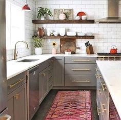 a rug in the middle of a kitchen with gray cabinets and white subway backsplash