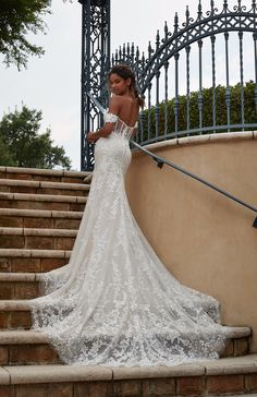 a woman in a wedding dress standing on some steps