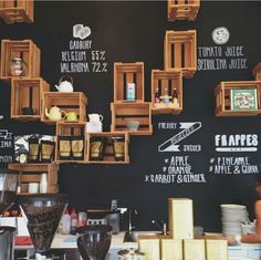 a blackboard wall with wooden crates and chalk writing on it, displaying different types of food