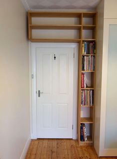 an empty room with bookshelves and a white door