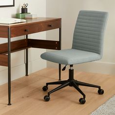 an office chair sitting in front of a desk with a book on top of it