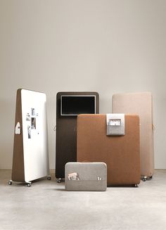 four different colored pieces of luggage sitting on the floor in front of a white wall