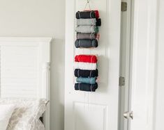 towels hanging on the wall next to a bed in a room with white walls and doors