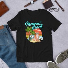 Perfect for anyone who loves cats, surf, and beach. Wear it proudly to the beach on vacation in Miami Florida. Share the Aloha. Makes a great summer costume. UNISEX PREMIUM SHIRT: This t-shirt feels soft and light, with just the right amount of stretch. It's comfortable and the unisex cut is flattering for both men and women. We can't compliment this shirt enough - it's one of our crowd favorites. And it's sure to be your next favorite too! * 100% combed and ring-spun cotton * Ash color is 99% c Summer Costume, Retro Miami, Beach Cat, Miami Shirt, Florida Beach, Beach Shirt, Florida Beaches, Beach Shirts, Miami Florida