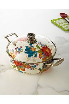 a floral covered casserole sits on a marble counter