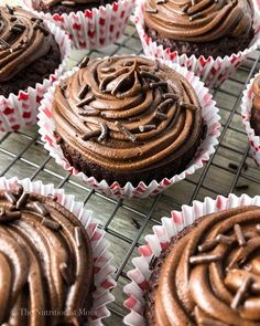 chocolate cupcakes with frosting and sprinkles on a cooling rack