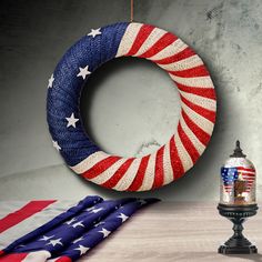 an american flag wreath next to a lamp on a table with other patriotic items around it