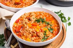 two bowls filled with soup on top of a wooden cutting board