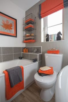 a bathroom with orange and gray decor on the walls