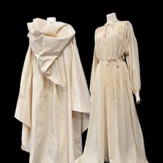 an old white dress and coat are on display