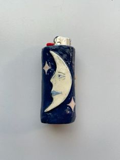 a blue lighter with a white moon and stars on the side, hanging from a hook