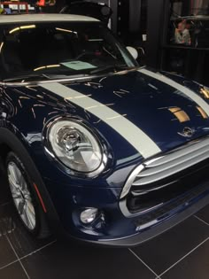 a blue and white car is parked in a showroom