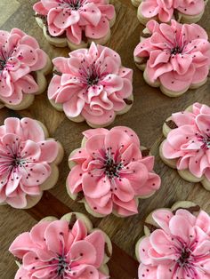 pink flowers are on top of cupcakes with icing