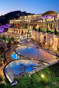 an aerial view of a resort at night with lights on the building and surrounding trees