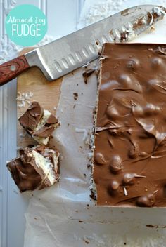 there is a piece of chocolate cake on the cutting board with a knife next to it