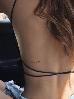 the back of a woman's neck with a small tattoo that reads, don't