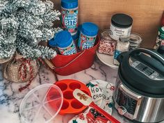 an assortment of holiday food and spices on a kitchen counter with the crock pot next to it