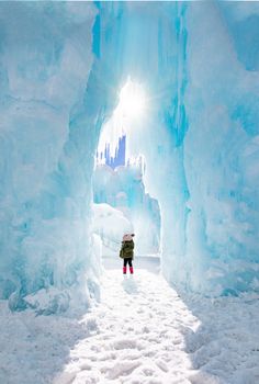 a person standing in the middle of an ice cave