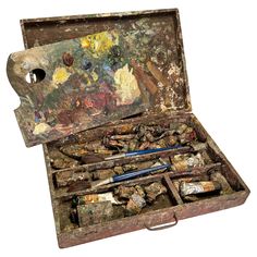 an old box filled with paint and brushes