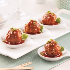 three small white plates filled with meatballs covered in sauce and garnishes