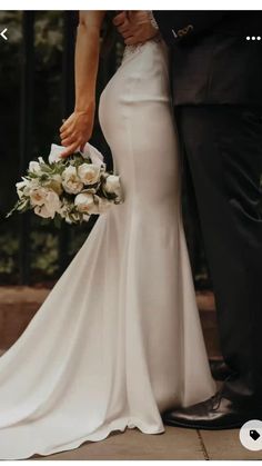 a bride and groom standing together in front of an iron gate at their wedding ceremony