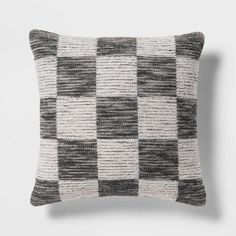 a black and white checkered pillow sitting on top of a wall