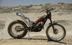 a dirt bike parked on top of a sandy hill