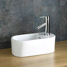 a white sink sitting on top of a wooden table