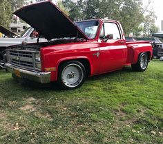 an old red truck with its hood open