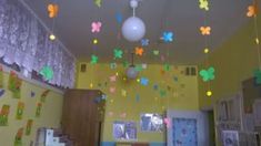 the room is decorated with colorful paper butterflies and lights hanging from the ceiling above it