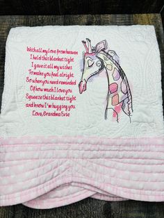 a pink and white quilted blanket with a giraffe on it's side